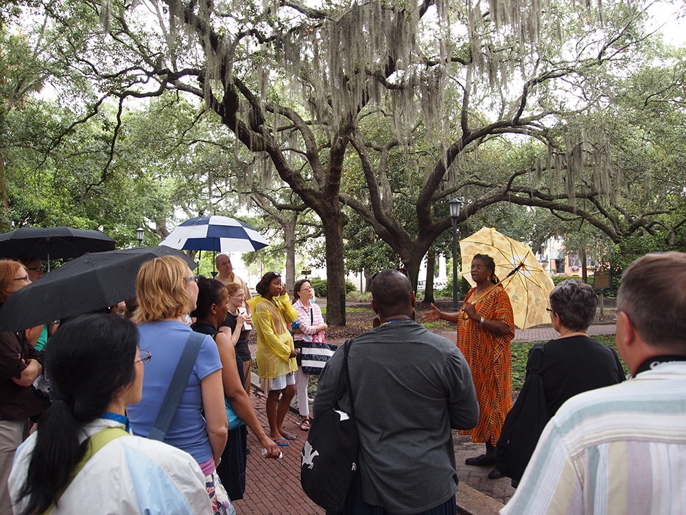 Group gathering around speaker in one of Savannah's squares.