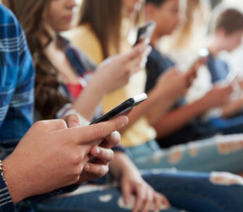 Students in a row looking at their smartphones